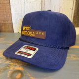 Navy blue corduroy baseball cap on a rustic wooden surface, highlighting its color and texture for casual wear.