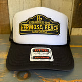 Black and white mesh trucker hat with front text embroidery, suitable for casual wear.