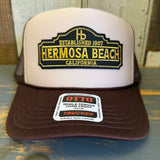 Brown khaki trucker hat with a high crown, mesh back, and structured front; suitable for casual, everyday wear.