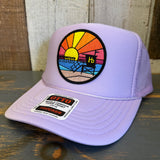 Lavender trucker hat with mesh back on rustic wood; ideal for sun protection and casual wear.