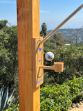 Golf putting game with wooden cup, swinging ball, and green turf for outdoor play.