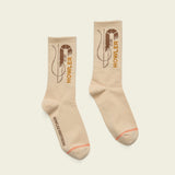 Pair of beige socks with 'Howler Brothers' logo on a light beige background.