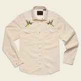 Beige shirt with embroidered hummingbirds on a beige background.