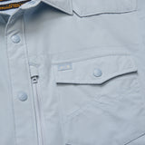 Sky blue long sleeve tech shirt with buttons, zip pocket, H+B logo, and UPF 35; lightweight fabric for outdoor use.