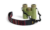 Textured green binoculars with a geometric-patterned woven strap, suitable for outdoor viewing.