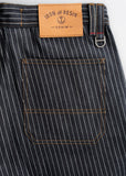 Dark wash denim pants with orange-stitched back pocket and leather label, suitable for casual or work wear.