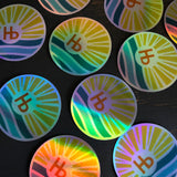 Holographic sticker featuring the Hermosa Beach logo in iridescent colors, made of durable material for decorating surfaces.