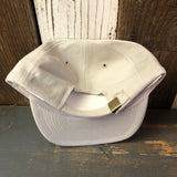 Light gray 6-panel baseball cap, cotton material, shown upside down on a rustic wooden surface.