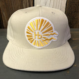 Beige 6-panel baseball cap made of brushed bull denim, displayed on a wooden surface.