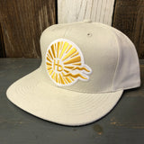 Beige 6-panel brushed denim cap resting on a wooden surface; simple, casual headwear in neutral tones.