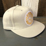 Brushed bull denim cap in classic style with HB initials, sunburst detail, adjustable strap, displayed on wood surface.