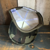 Inside-out camo foam cap displaying mesh lining and stitching, highlighting material and construction details.