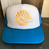 Neon blue and white trucker hat with mesh back sits on a wooden surface.