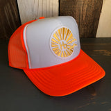 Neon orange and white trucker hat with mesh back, featuring a yellow sunburst HB patch on the front.