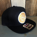 Black 5-panel snapback hat with a gold logo, suitable for casual wear.