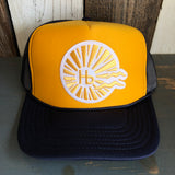 Navy and gold trucker hat with mesh back and adjustable snapback closure.