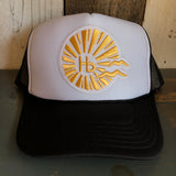 Trucker hat with gold sunburst and hb logo on front, mesh back, suitable for everyday use.