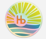 Holographic sticker with waves, sun rays, and an orange Hb symbol; suitable for decorating laptops or water bottles.