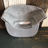 Light grey snapback hat with adjustable strap, displayed on rustic wood background