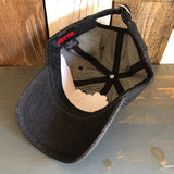 Black denim 6-panel dad hat, inside out, displayed on a wooden surface.